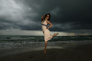 Fototapeta na wymiar Young woman dancing on a beach