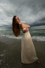 Fototapeta na wymiar Beautiful woman standing on the beach
