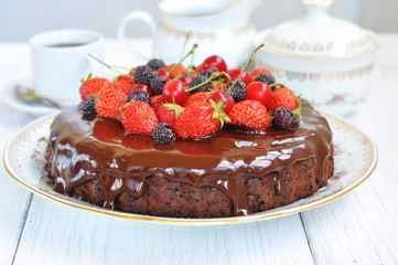 Chocolate cake with chocolate icing and berries, selective focus