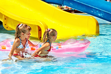 Child on water slide at aquapark.