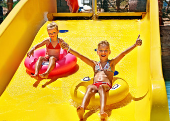 Child on water slide at aquapark.