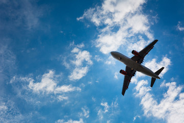 Fototapeta na wymiar Dark silhouette of an airplane flying over the blue skies