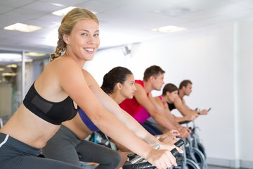 Fototapeta premium Blonde smiling at camera during spin class