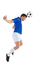 Fototapeta premium Football player in blue jersey heading ball