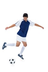 Fototapeta na wymiar Football player in blue kicking ball