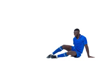 Football player in blue sitting and smiling