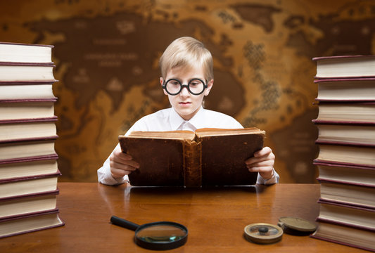 Retro Style Portrait Of A Reading Boy Against An Old World Map