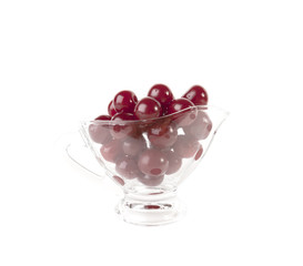 Red cherries in glass vase isolated on white