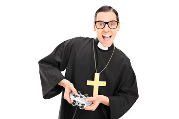 Joyful priest holding a gamepad