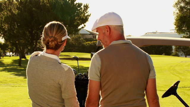 Couple standing on the golf course looking around