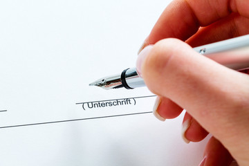 Hand mit Füllfeder bei Unterschrift