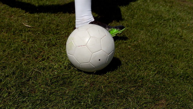 Football player kicking the ball on grass