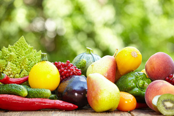 Fresh organic vegetables ane fruits on wood table  in the garden