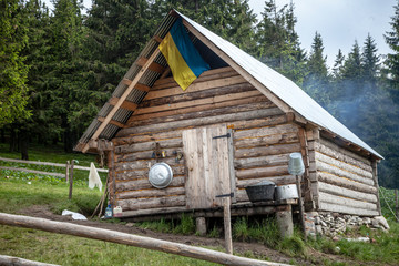 Obraz premium Wooden kolyba hut with a Ukrainian flag