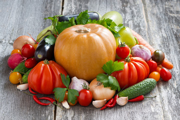 harvest of seasonal fresh vegetables on a wooden background