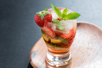 refreshing cocktail with strawberry and citrus on wooden tray
