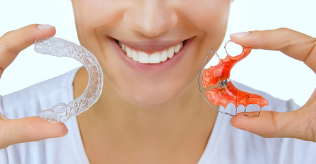 hands holding retainer for teeth and tooth tray - obrazy, fototapety, plakaty