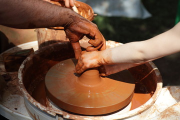 Hands of potters on a wheel