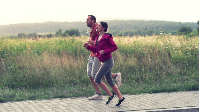Young couple jogging in the country, super slow motion