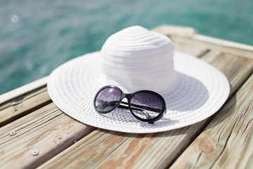 close up of hat and sunglasses at seaside