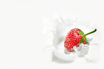 Red strawberry falling into the milky splash - 67514854