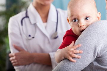 Baby boy in the arms of mother at doctor's office