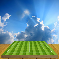 Soccer field board game on wooden floor with nice sky