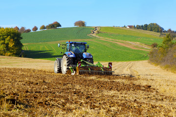 farm tractor on the field working, plowing land