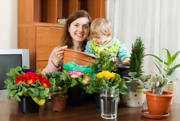 Mother with a toddler transplanting potted flowers