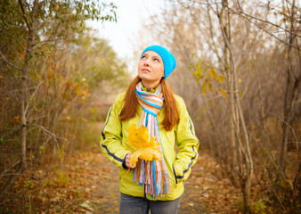 Young woman walking in the fall season. Autumn outdoor portrait