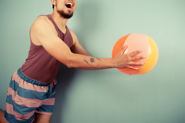 Young man catching beach ball