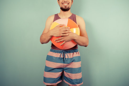 Happy young man with a beach ball