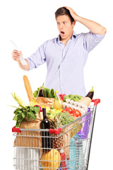 Man looking at the shopping bill in disbelief