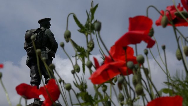 Soldiers World War Memorial Statue with red poppies