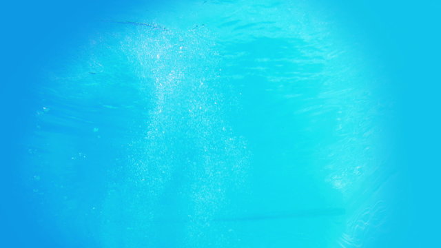 Pretty brunette diving underwater into pool
