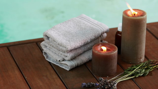 Towels candles and dried lavender by the pool