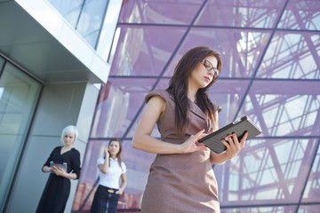 Fototapeta premium businesswomen with tablets and phones on the street