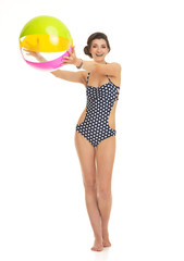 Full length portrait of happy woman in swimsuit with beach ball