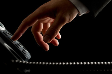 Hand of a businessman dialing or initiating a call - obrazy, fototapety, plakaty