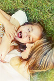 happy little girl and her mother having fun outdoors on the gras