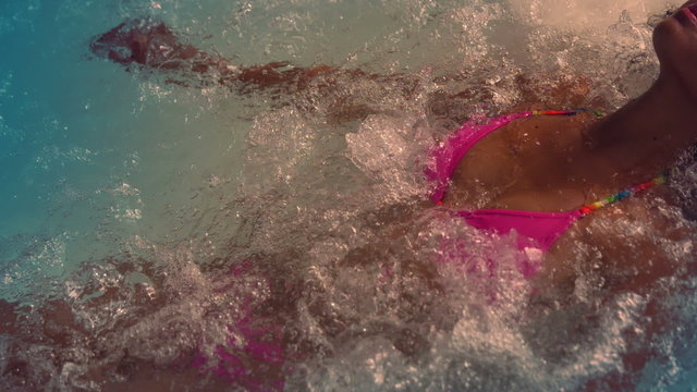 Happy woman in pink bikini relaxing in jacuzzi
