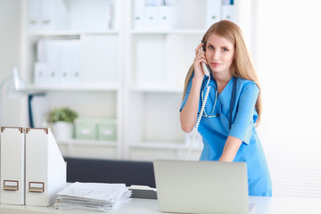 Medical doctor woman with computer and telephone.