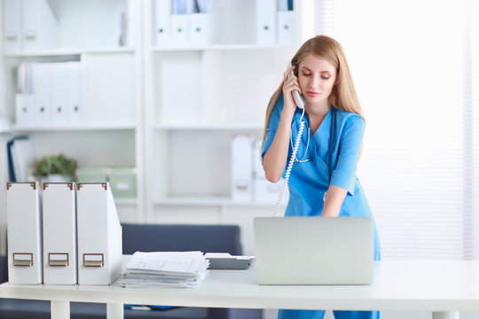 Medical doctor woman with computer and telephone.