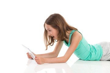 Surprised teen girl using digital tablet