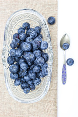 Fresh blueberries in oval glass dessert bowl and spoon