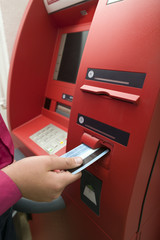 Men hand businessman puts credit card into ATM