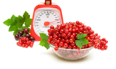 juicy redcurrants, kitchen scales and cherries on a white backgr