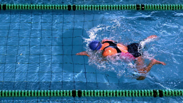 Fit female swimmer doing the breast stroke in swimming pool
