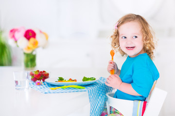 Little sweet girl eating salad for lunch