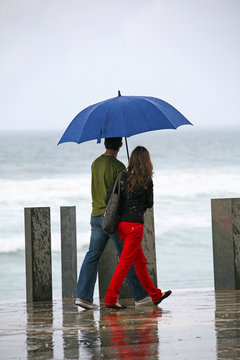 pareja con paraguas paseando por el malec&oacute;n de zarautz pa&iacute;s vasco 2994-f14